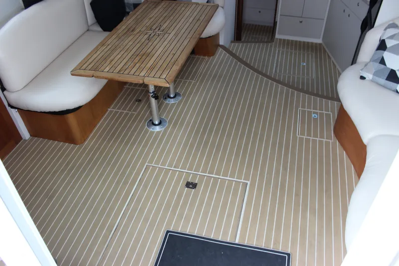 Slide: The Image of Interior of a 1997 Silverton 351 Sedan with wood table and cushioned seating. - 24