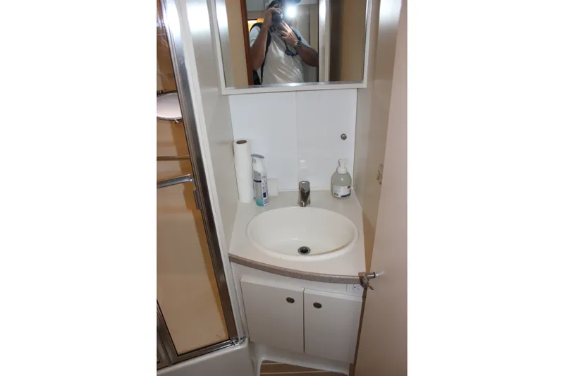 Slide: The Image of Bathroom sink area in a 1997 Silverton 351 Sedan yacht, featuring a mirror and toiletries. - 39