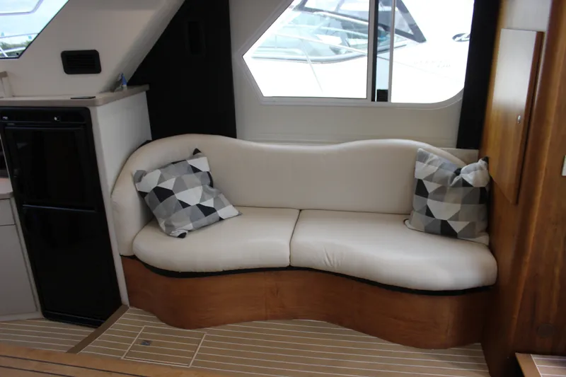 Slide: The Image of Interior of a 1997 Silverton 351 Sedan with a curved white sofa and geometric pillows. - 30