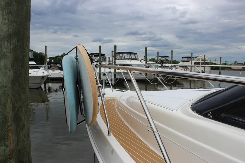 Slide: The Image of 1997 Silverton 351 Sedan yacht docked with paddleboards, under cloudy skies. - 78