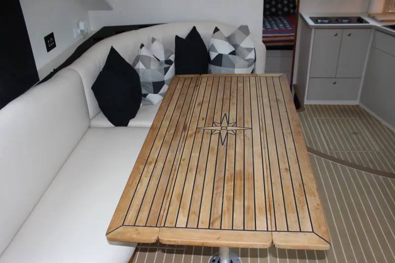 Slide: The Image of 1997 Silverton 351 Sedan interior with wooden table, cushioned seating, and decorative pillows. - 29