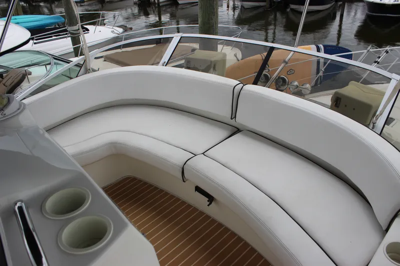 Slide: The Image of 1997 Silverton 351 Sedan boat with white seating and wooden deck, docked at marina. - 14