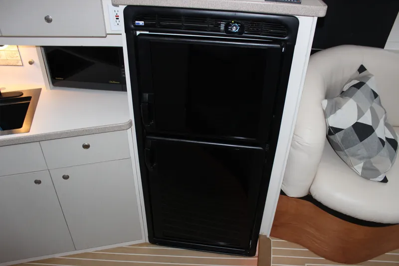 Slide: The Image of Interior of a 1997 Silverton 351 Sedan with kitchenette and black refrigerator. - 51