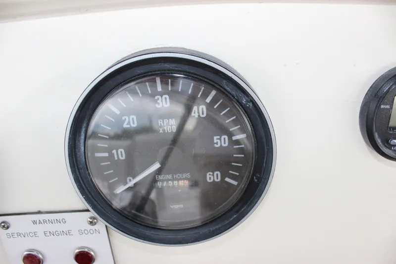 Slide: The Image of 1997 Silverton 351 Sedan tachometer showing RPM and engine hours with service warning light. - 18