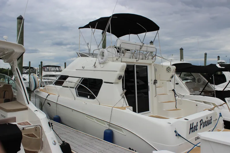 The Image of 1997 Silverton 351 Sedan yacht docked at marina under cloudy sky. - 3