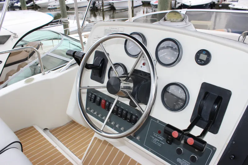 Slide: The Image of 1997 Silverton 351 Sedan helm with steering wheel, gauges, and controls at marina. - 17