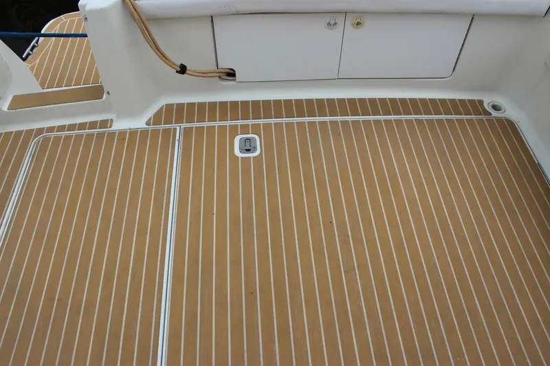 Slide: The Image of 1997 Silverton 351 Sedan boat deck with teak-style flooring and storage compartments. - 62