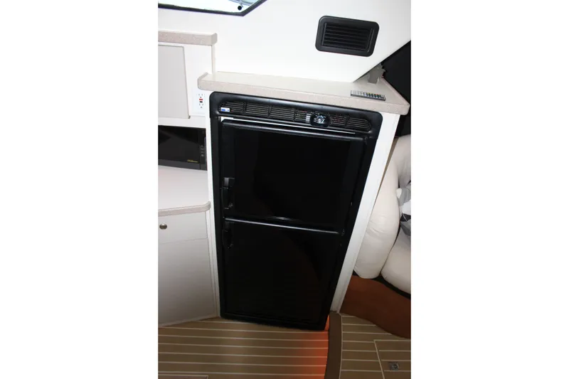 Slide: The Image of Interior of 1997 Silverton 351 Sedan featuring a compact black refrigerator. - 34