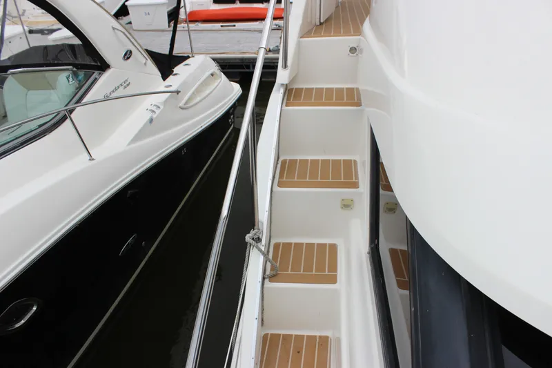 Slide: The Image of 1997 Silverton 351 Sedan yacht with wooden steps and sleek design at a marina. - 13