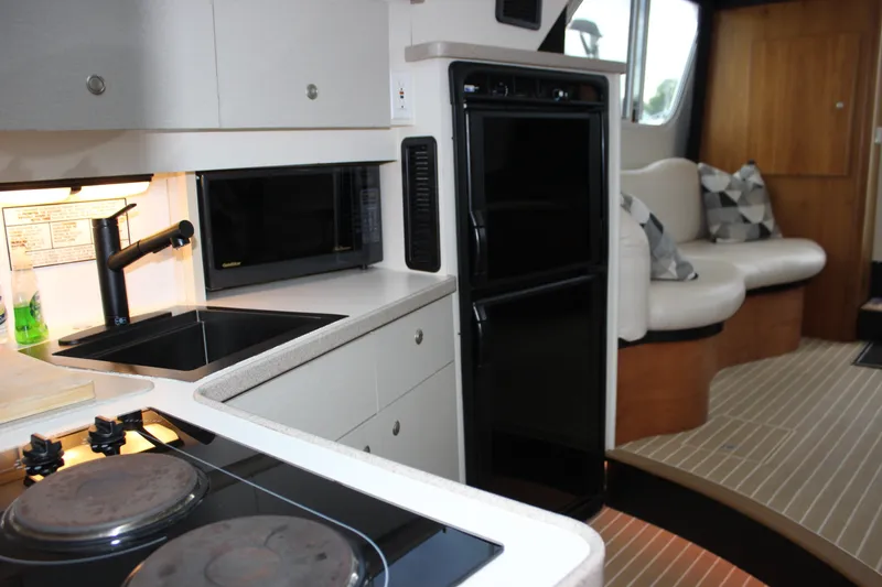 Slide: The Image of Interior of a 1997 Silverton 351 Sedan yacht with kitchen and seating area. - 60