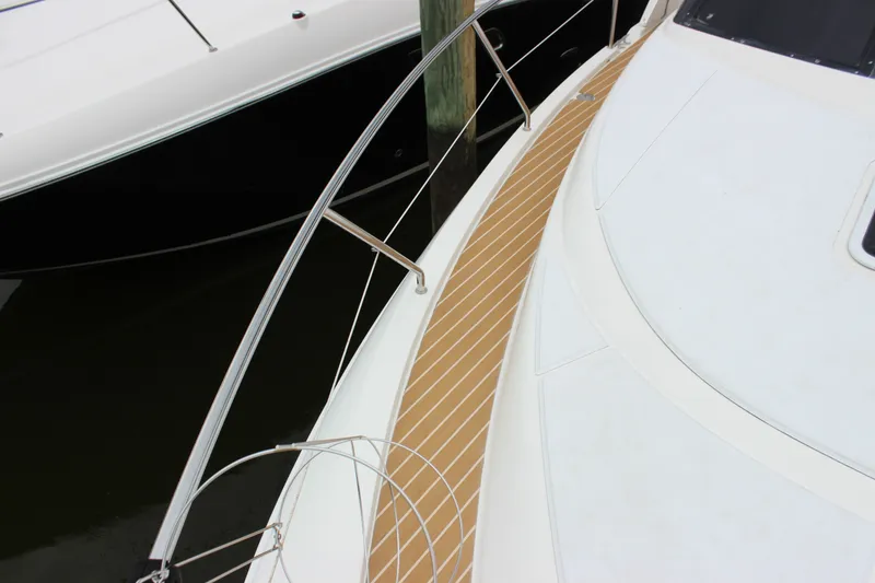 Slide: The Image of 1997 Silverton 351 Sedan yacht deck with sleek railing and wood-patterned flooring. - 49