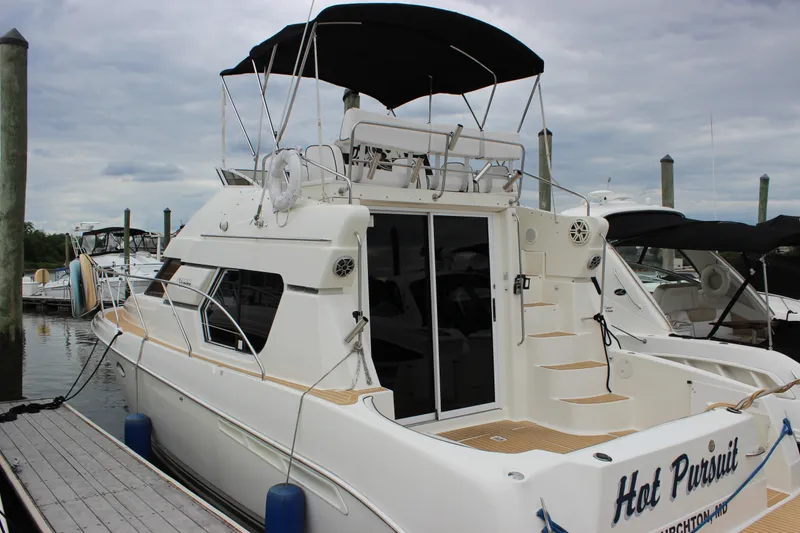 Slide: The Image of 1997 Silverton 351 Sedan yacht docked at marina, featuring spacious deck and sleek design. - 77