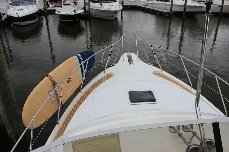 Slide: The Image of 1997 Silverton 351 Sedan yacht with surfboard, docked in marina. - 40