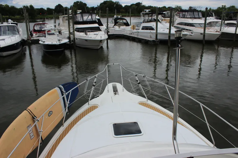 Slide: The Image of 1997 Silverton 351 Sedan yacht docked with paddleboard on deck, surrounded by other boats. - 41