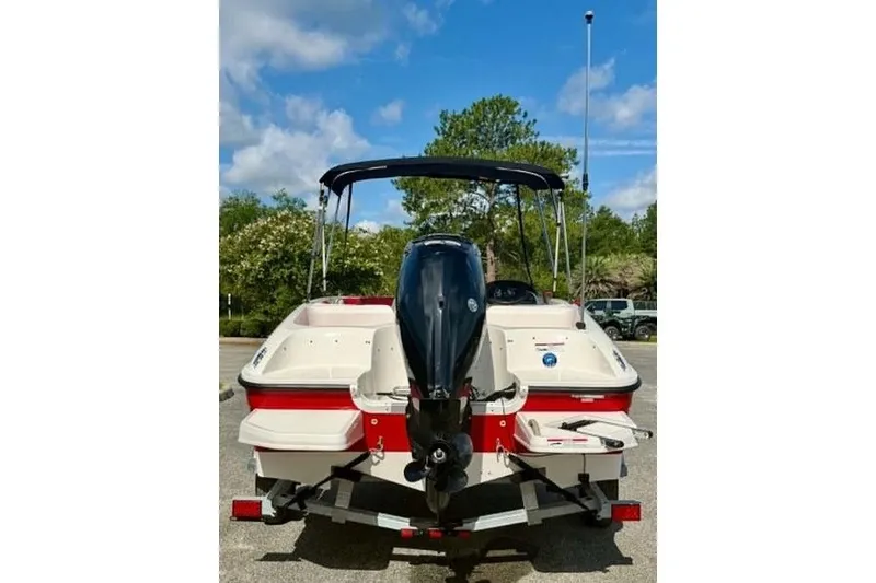Slide: The Image of 2021 Bayliner Element E16 boat with outboard motor, parked outdoors under a clear sky. - 6