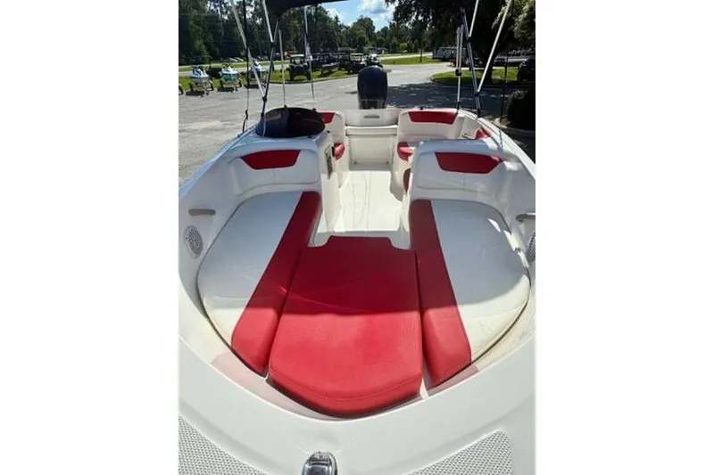 Slide: The Image of 2021 Bayliner Element E16 boat interior with red and white seating, parked outdoors. - 8