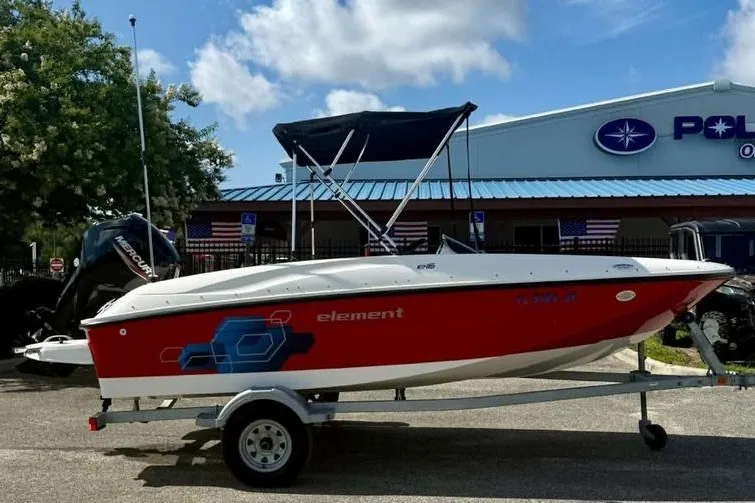 Slide: The Image of 2021 Bayliner Element E16 boat on trailer, red and white design, parked outdoors. - 4