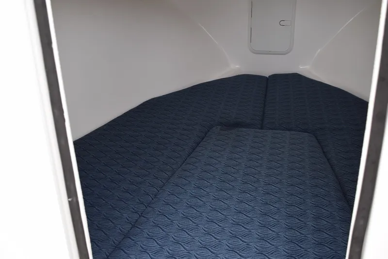 Slide: The Image of 2023 NorthCoast 215 HT cabin interior with blue cushioned bedding. - 17