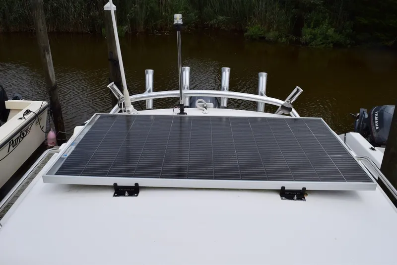 Slide: The Image of 2023 NorthCoast 215 HT boat with solar panel on deck, docked by water. - 24