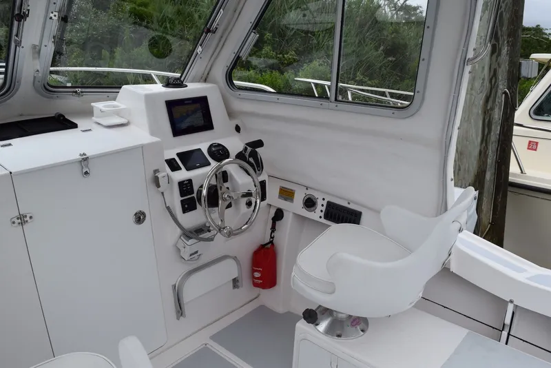 Slide: The Image of 2023 NorthCoast 215 HT boat interior with steering wheel and control panel. - 14