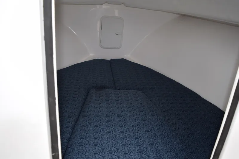 Slide: The Image of 2023 NorthCoast 215 HT cabin interior with blue cushioned bedding. - 18