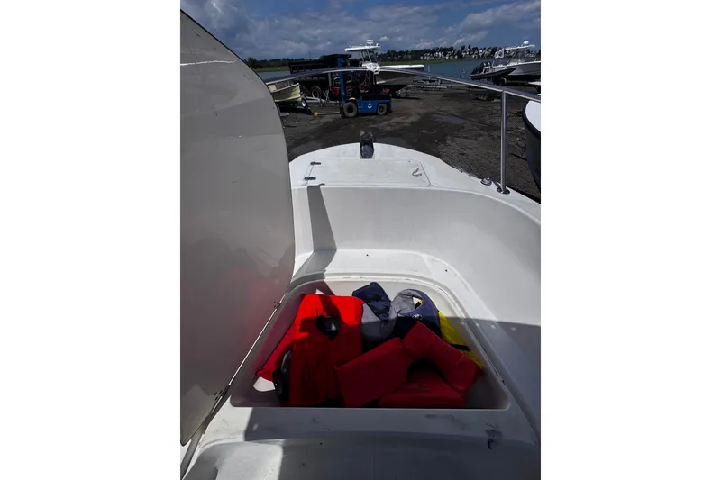 Slide: The Image of 2001 Boston Whaler 23 Outrage boat with open storage compartment and life jackets. - 16