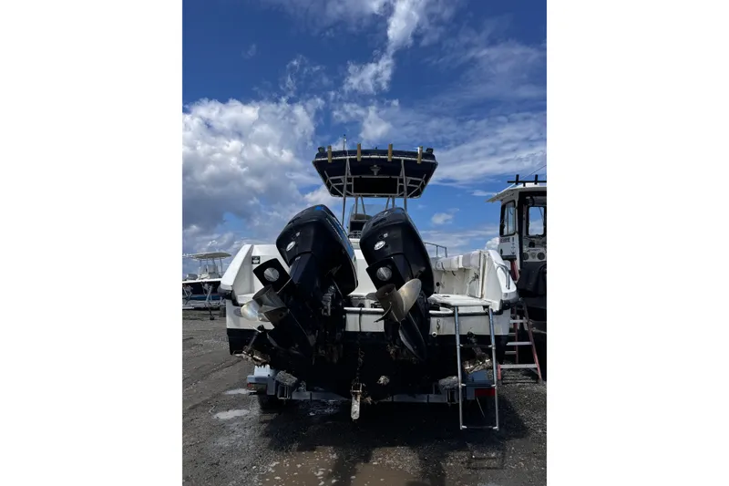 Slide: The Image of 2001 Boston Whaler 23 Outrage boat with dual outboard motors under a blue sky. - 1