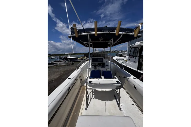Slide: The Image of 2001 Boston Whaler 23 Outrage boat with T-top, docked under a blue sky. - 21