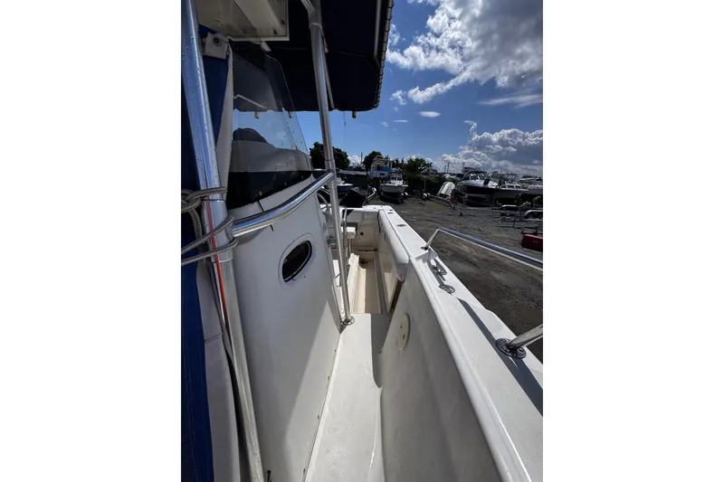 Slide: The Image of 2001 Boston Whaler 23 Outrage boat, side view, under a partly cloudy sky. - 12
