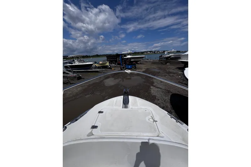 Slide: The Image of 2001 Boston Whaler 23 Outrage boat on a dock with cloudy sky background. - 13