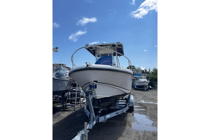 Slide: The Image of 2001 Boston Whaler 23 Outrage boat on trailer under clear blue sky. - 3