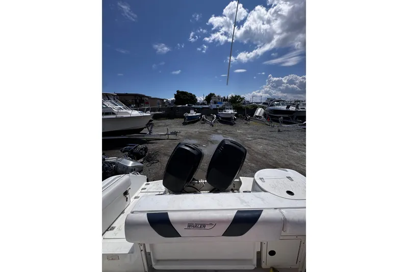 Slide: The Image of 2001 Boston Whaler 23 Outrage boat with dual engines in a marina under a cloudy sky. - 6