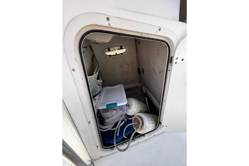 Slide: The Image of Storage compartment of a 2001 Boston Whaler 23 Outrage boat with equipment and supplies. - 17