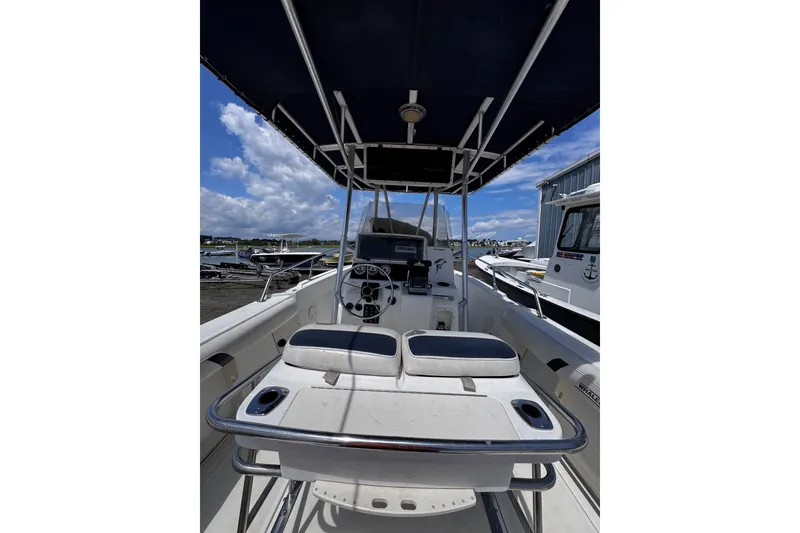 Slide: The Image of 2001 Boston Whaler 23 Outrage boat interior with steering console and seating under canopy. - 8
