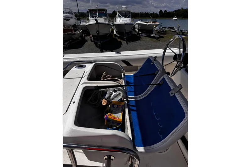 Slide: The Image of 2001 Boston Whaler 23 Outrage boat interior with blue seating and storage compartments. - 19