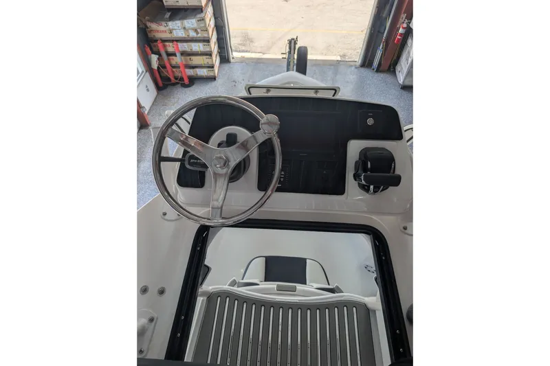 Slide: The Image of Steering console of 2027 Tidewater 2410 Bay Max boat in a garage setting. - 20