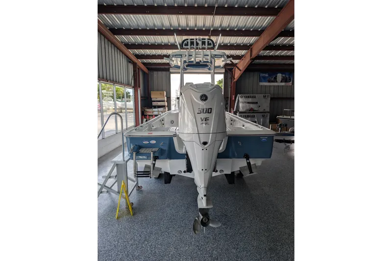Slide: The Image of 2027 Tidewater 2410 Bay Max boat in a showroom, featuring a powerful outboard motor. - 23