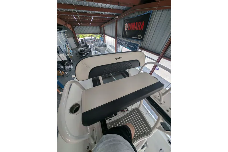 Slide: The Image of 2027 Tidewater 2410 Bay Max boat interior with seating and Yamaha banner in showroom. - 21