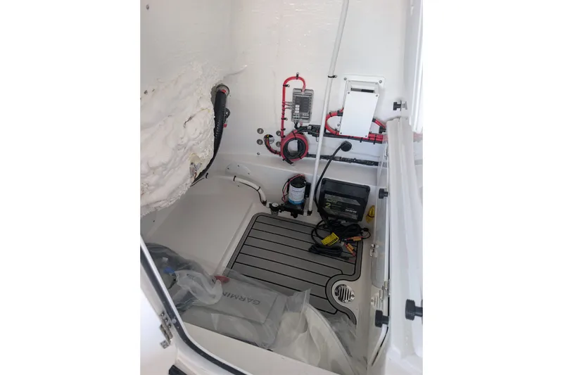 Slide: The Image of Interior view of 2027 Tidewater 2410 Bay Max boat's storage compartment with wiring and equipment. - 22