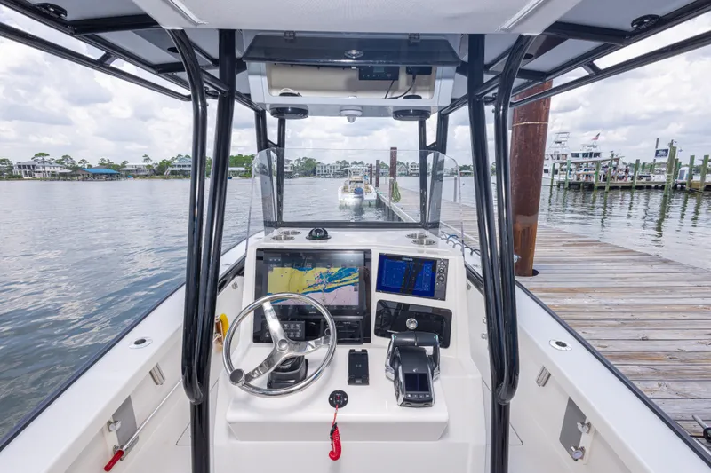 Slide: The Image of Calcutta 263 boat dashboard with navigation screens, steering wheel, and controls, docked at marina. - 64
