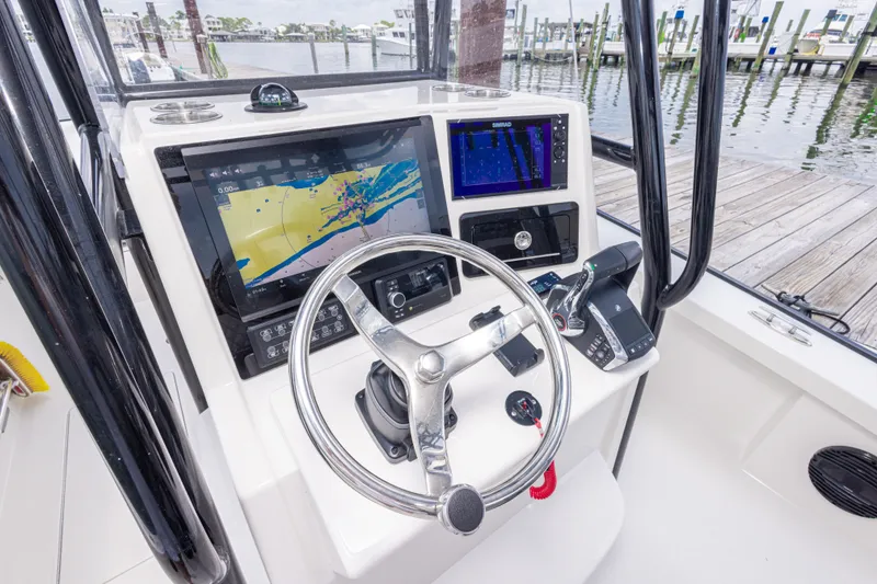 Slide: The Image of Calcutta 263 boat dashboard with navigation screens and steering wheel, docked at marina, 2026 model. - 56