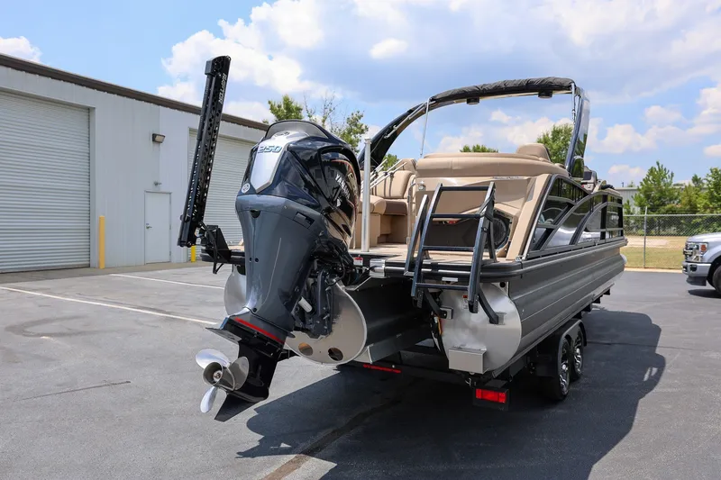 Slide: The Image of 2023 Bennington Q 25 QFBA pontoon boat with powerful outboard motor in parking lot. - 2