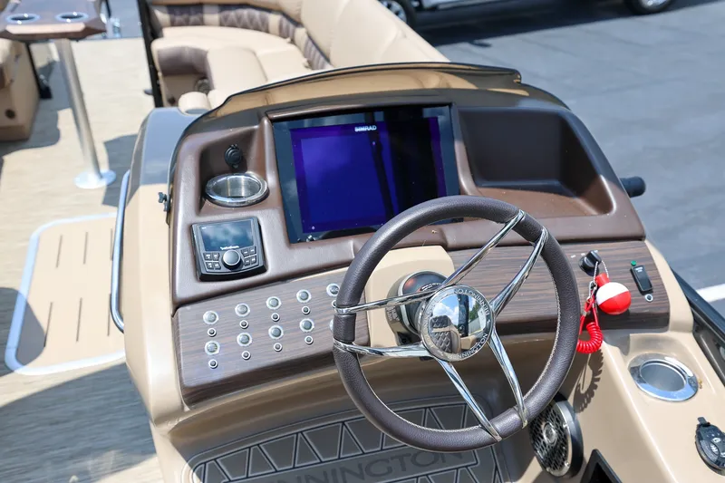 Slide: The Image of 2023 Bennington Q 25 QFBA boat dashboard with steering wheel and control panel. - 11