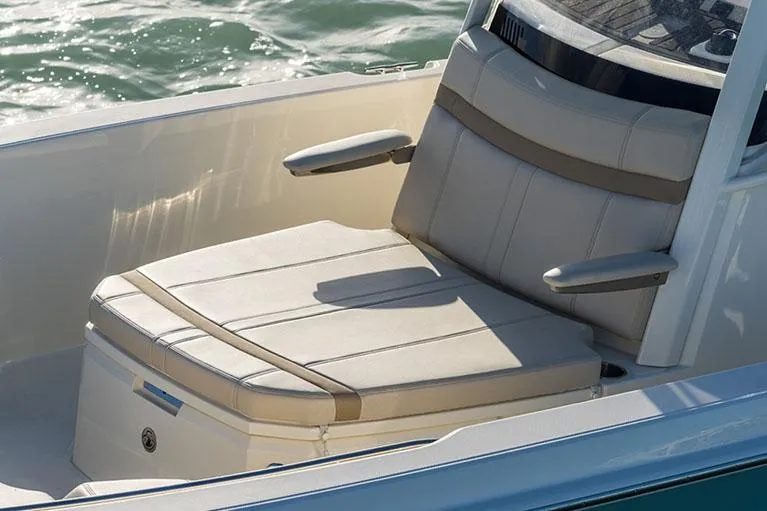 Slide: The Image of Manufacturer Provided Image: 2026 Boston Whaler 250 Dauntless boat seat with armrests, on calm water. - 6