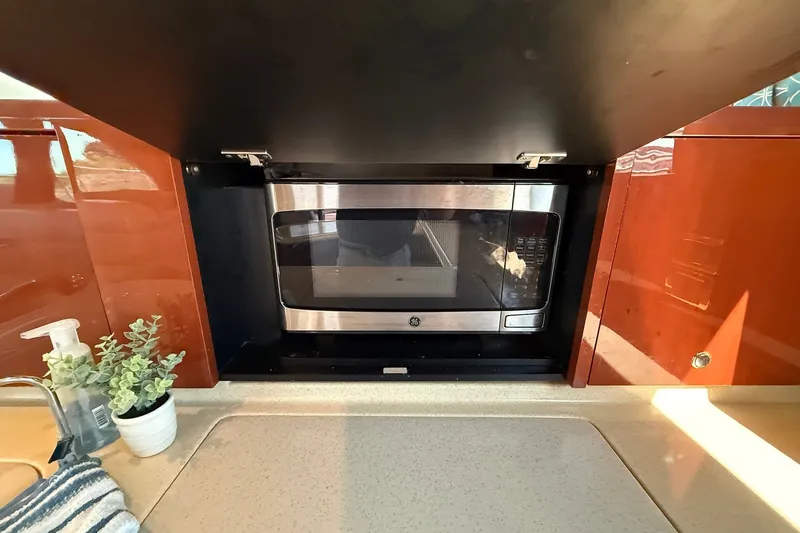 Slide: The Image of Kitchen area of 2002 Sea Ray 560 Sedan Bridge with built-in microwave. - 68