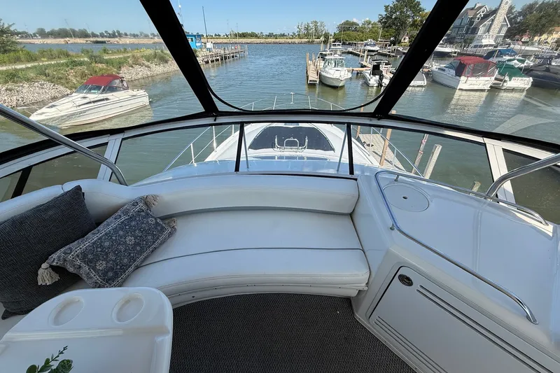 Slide: The Image of 2002 Sea Ray 560 Sedan Bridge yacht interior with marina view, featuring plush seating and elegant design. - 24