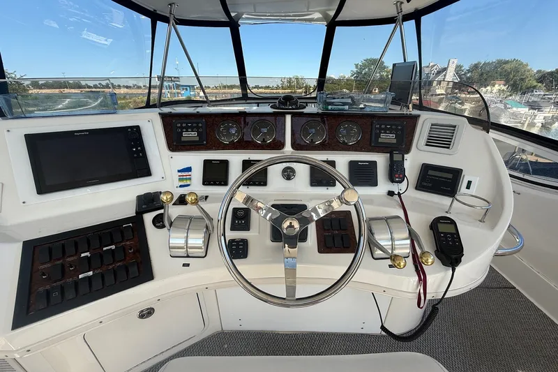 Slide: The Image of 2002 Sea Ray 560 Sedan Bridge helm with steering wheel, controls, and navigation equipment. - 35
