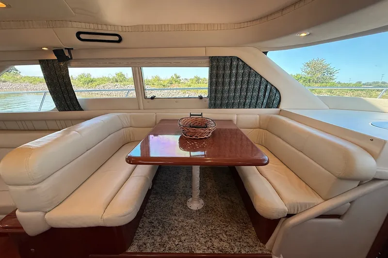 Slide: The Image of Luxurious interior of 2002 Sea Ray 560 Sedan Bridge with elegant dining area and panoramic windows. - 58
