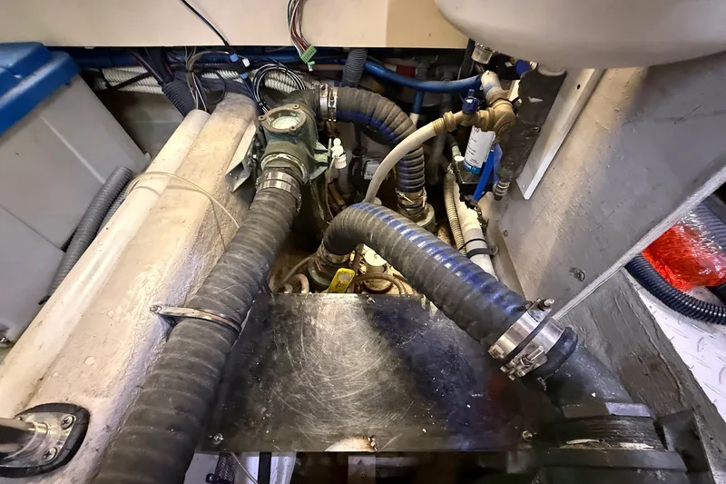 Slide: The Image of Engine room of a 2002 Sea Ray 560 Sedan Bridge with visible hoses and fittings. - 121