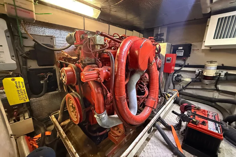 Slide: The Image of Engine room of a 2002 Sea Ray 560 Sedan Bridge with red machinery and equipment. - 118